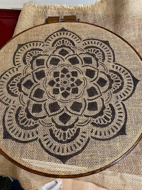 Photo of mandala stenciled burlap being put into quilting hoop