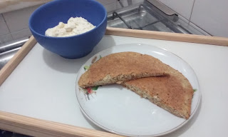 Pão de amêndoas numa travessa e patê de queijo coalho numa tigela azul