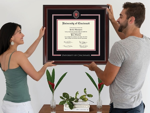 a couple hanging a diploma on a wall