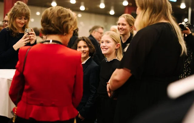 Queen Sonja wore a red peplum jacket and black skirt and a fur detail red cashmere poncho cape.  The Youth Orchestra Federation