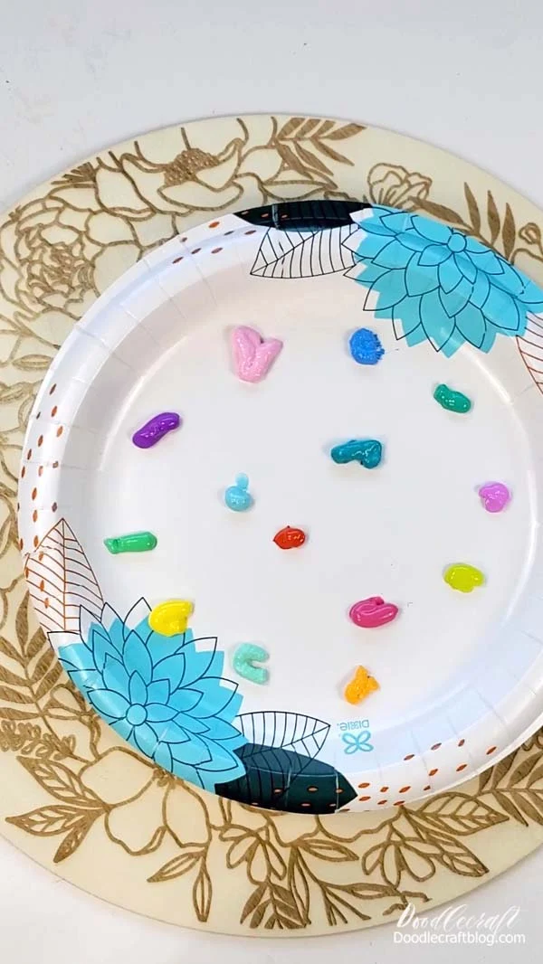 Begin by squeezing a pea sized amount of paint on a palette.   I'm using a paper plate as my palette, wax paper is another one of my favorite go-to palettes.    Which is funny because I have real palettes, lol.   You will also need a cup of water nearby and a paper towel or napkin for blotting.