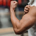 Crop unrecognizable sportsman showing bicep in gym