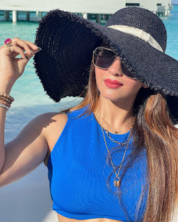 taking sun light in blue bikini with big black hat