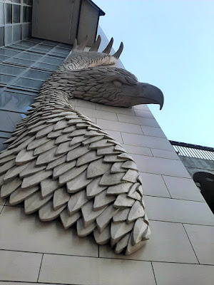 A huge carved eagle in flight, sculpted on the side of a condo building