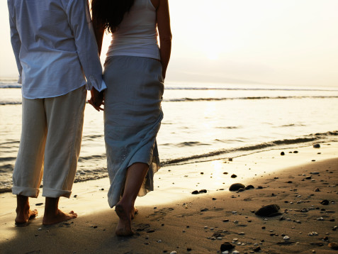 A Couple Holding Hands On The Beach. Couple holding hands on