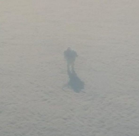 A plane passenger spotted a mysterious figure walking on the clouds 30,000 ft. above the ground.
