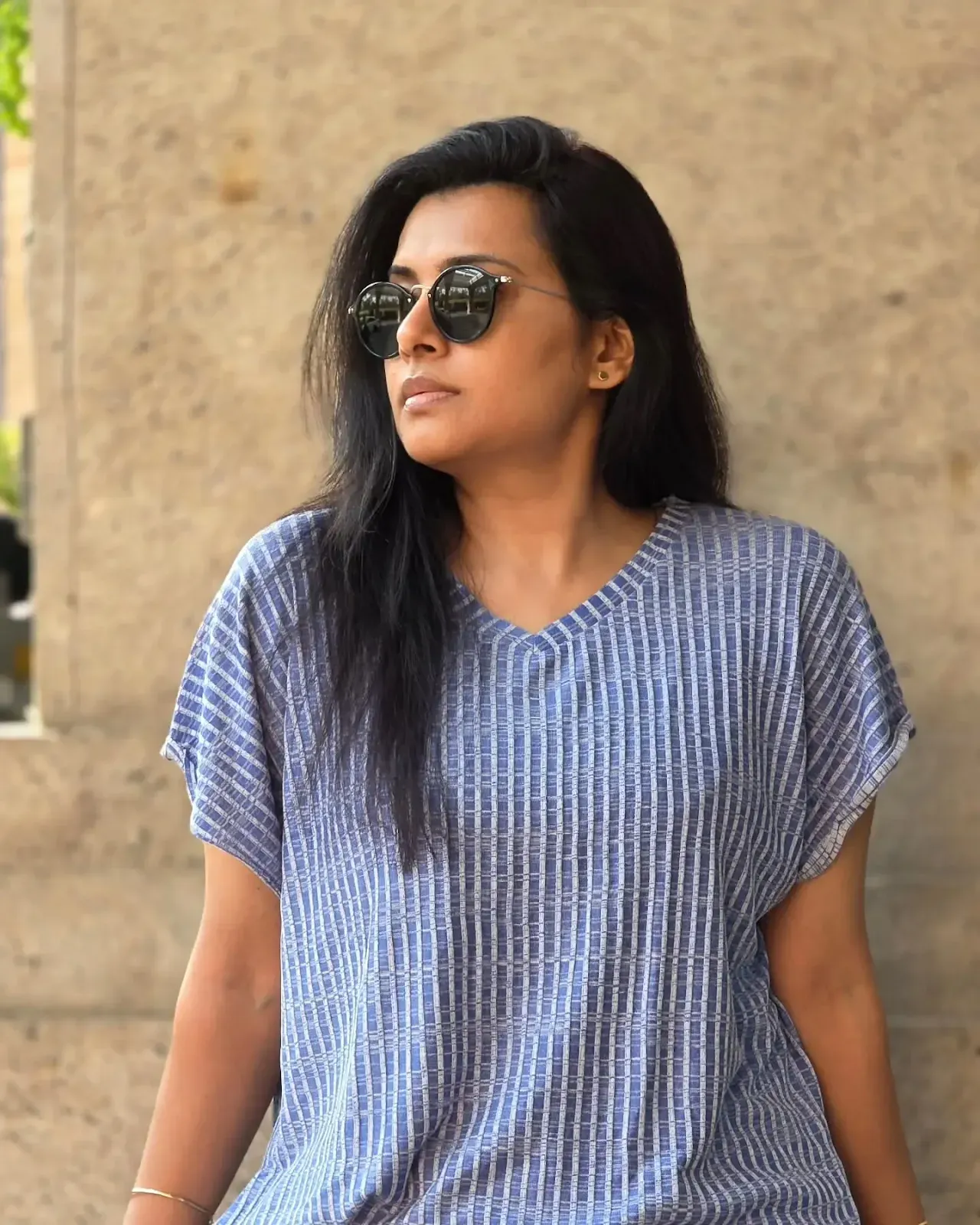 Sruthi Raj showcases a chic modern look in a white crop top and ripped jeans, radiating youthful charm.