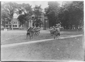 Students performing military drills in front of Webster Hall