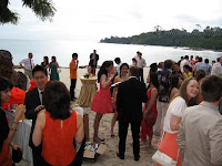 Guests chatting and having their cocktails by the beach