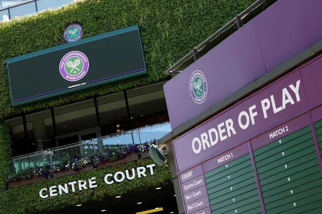 Entrada de Wimbledon, com decoração verde e a tabela em verde e rosa