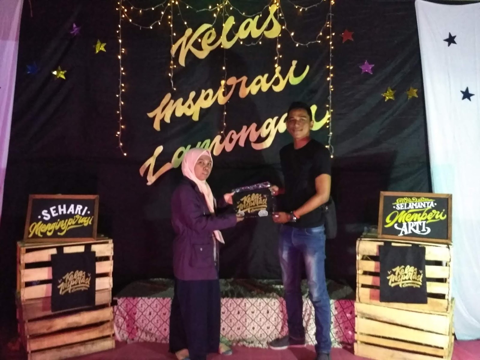 Salah satu pengurus berkesempatan untuk foto dengan background Kelas Inspirasi Lamongan saat mendapat hadiah tersebut sebelum stand di bongkar karena