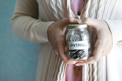 Mujer con tarro de ahorros en la mano