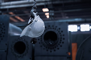 white-hardhat-hanging-from-crane-hook