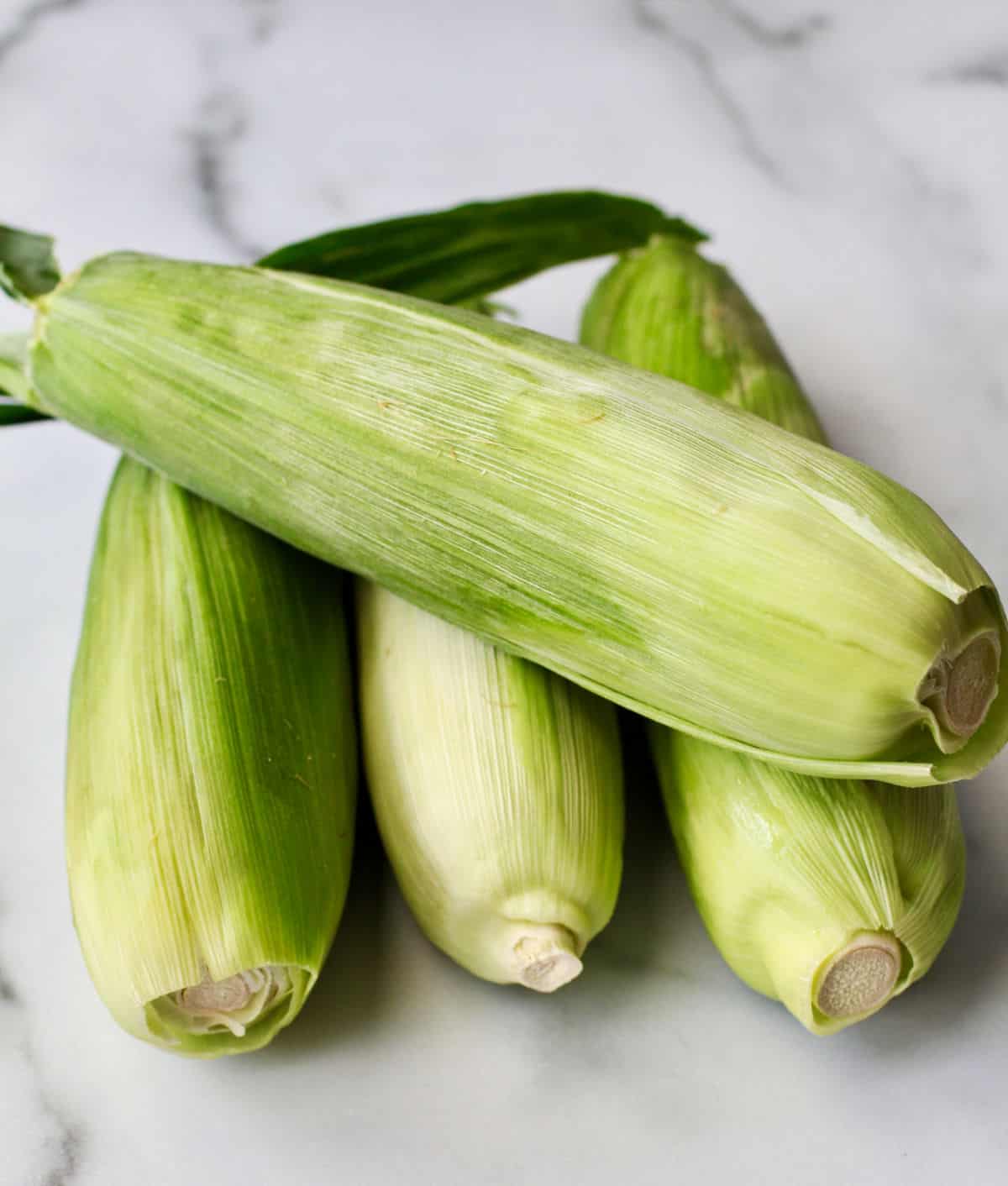 Corn cobs with husks.