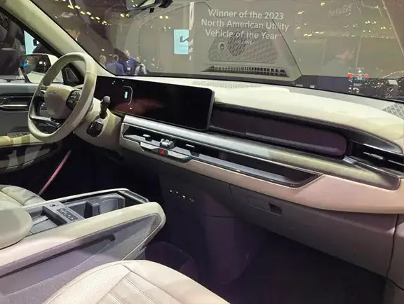 The interior of the Kia EV9 electric SUV is shown, as seen from the passenger side door.