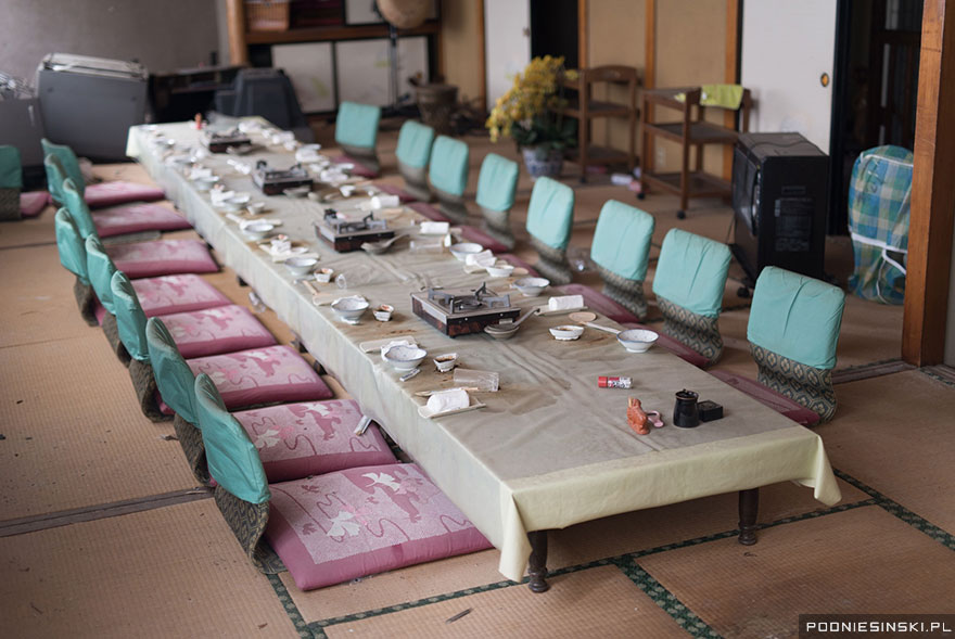 A dining table with portable cookers ready to prepare food looks like it was left in haste - Never-Before-Seen Images Reveal How The Fukushima Exclusion Zone Was Swallowed By Nature