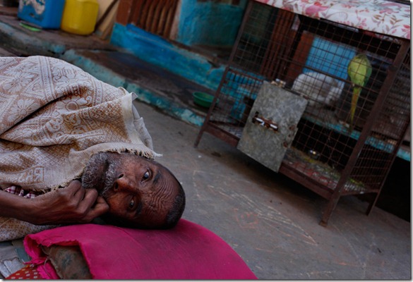 In this Friday, Aug. 7, 2009 photograph, Hira Lal, who has lost the ability to move and hear, lays on a makeshift bed outside his shanty in Bhopal, India. (AP Photo/Saurabh Das)