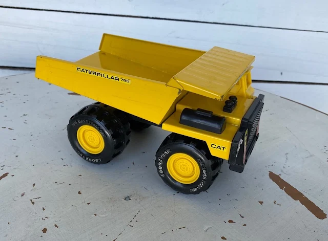 Photo of a metal yellow dump truck toy.
