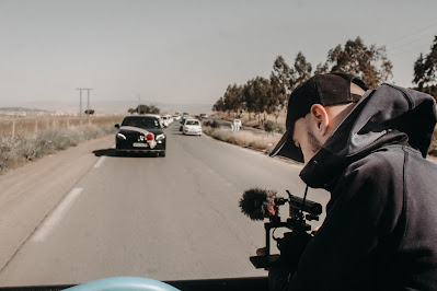 Videógrafo filmando al coche nupcial en la carretera