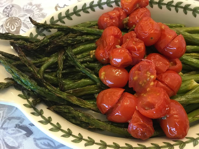 roasted asparagus on a fancy plate with roasted tomatoes