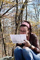 Female, outside looking at a trail map.