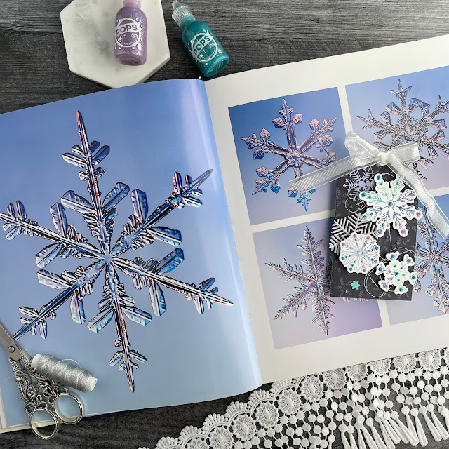 Ombre stamped snowflake tags created with: Scrapbook.com dainty snowflakes stamp and die set, peppermint patterned paper, solar white cardstock, pops of color lavender luster royal blue teal twinkle snowflake, snowflakes die, glitter metals paper; Tim Holtz distress oxide salvaged patina shaded lilac, faded jeans