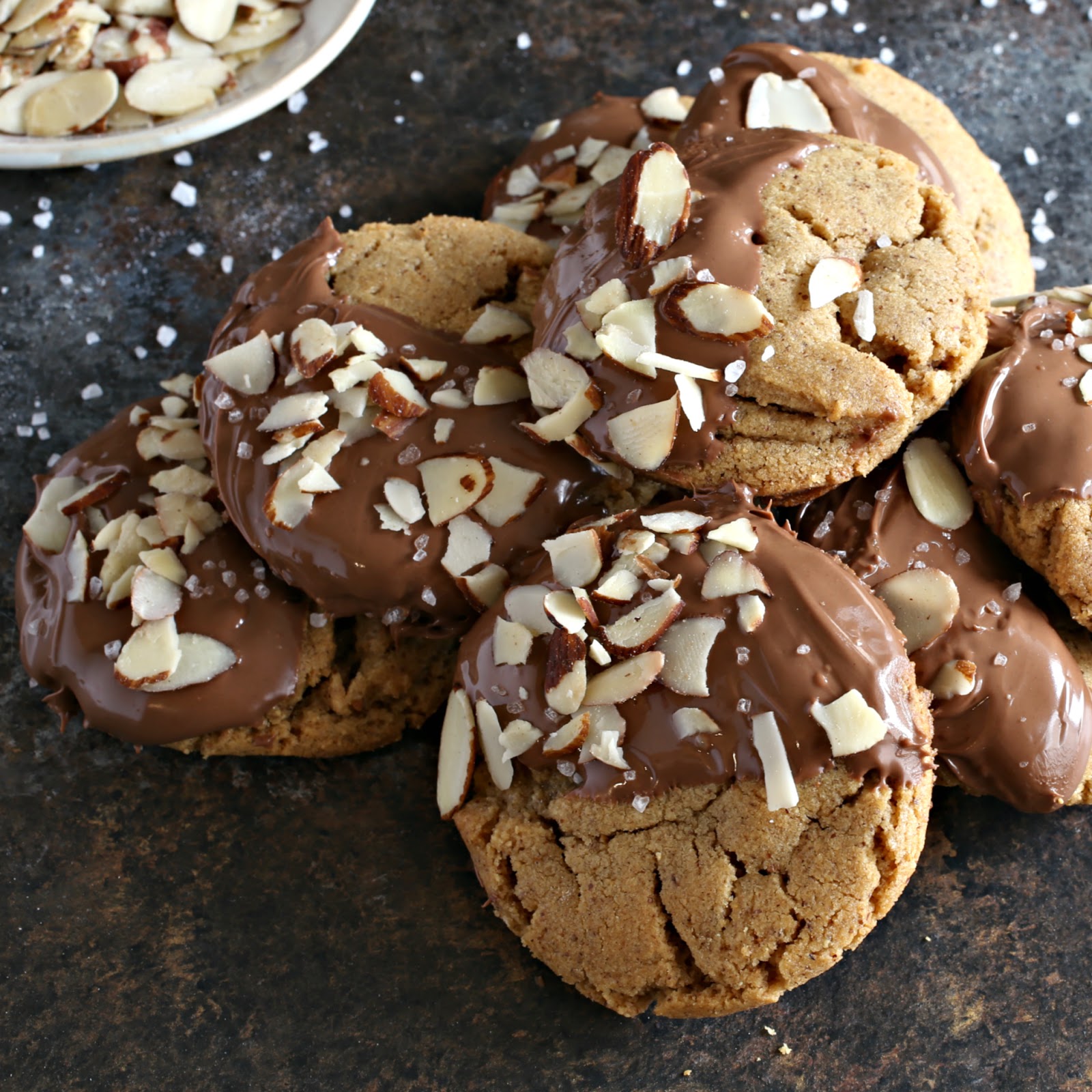 Almond butter cookies coated with chocolate and sprinkled with slivered almonds and sea salt.