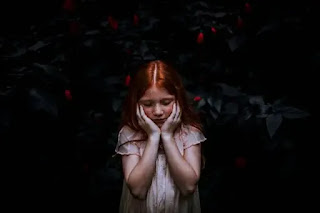 An image of a cute child girl with her hands on her face- sad girl dp
