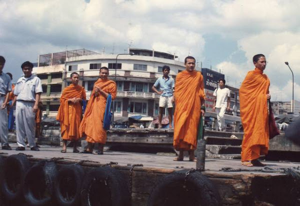 Monks standing on the river bank.