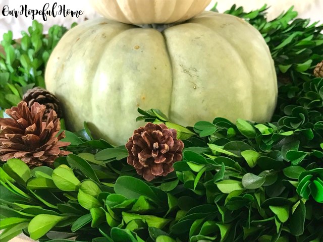 Farmhouse fall decor in tobacco basket with boxwood wreath pumpkins pinecones