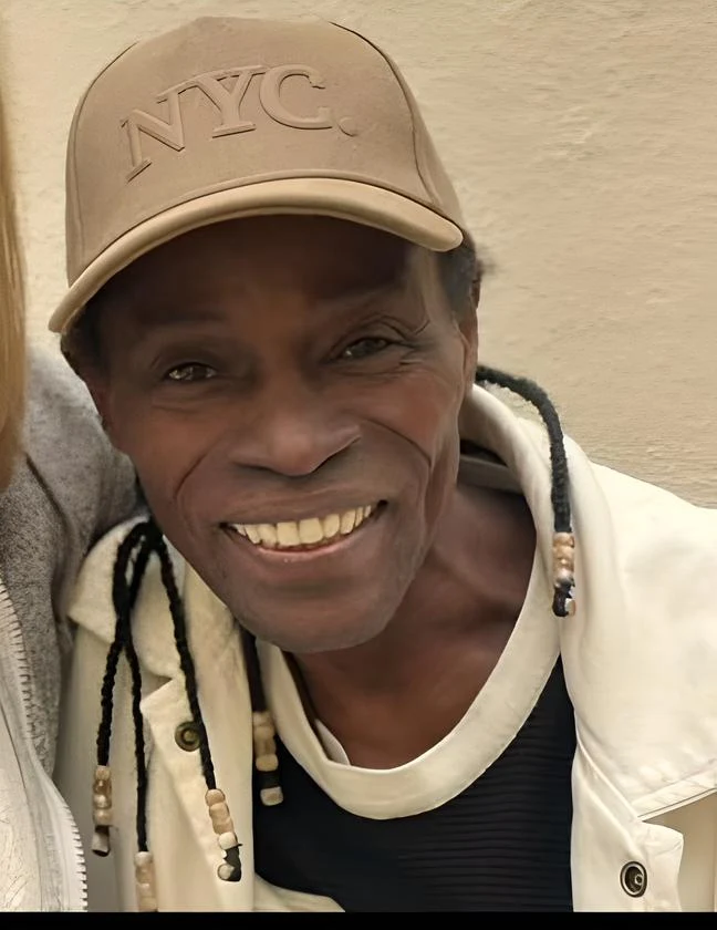 Eduardo paim Homem sorridente com boné NYC, destacando um estilo descontraído. A imagem capta a essência da cultura urbana e da moda de Nova York.