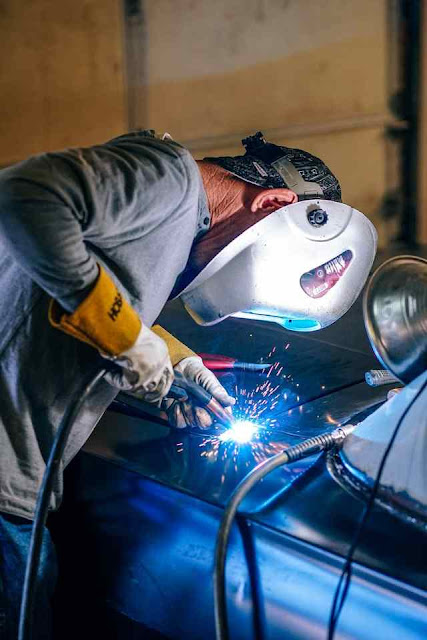 安全具を身に着けて車に溶接する男性