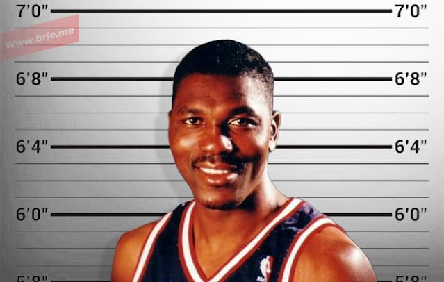 Hakeem Olajuwon posing in front of a height chart background