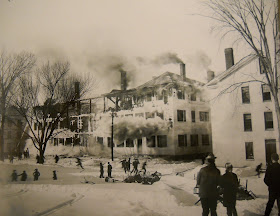 A black and white photograph of a burning hall.