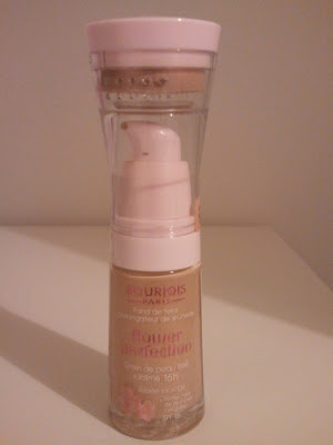 beige foundation bottle with large white pump and round sponge applicator encased within cap