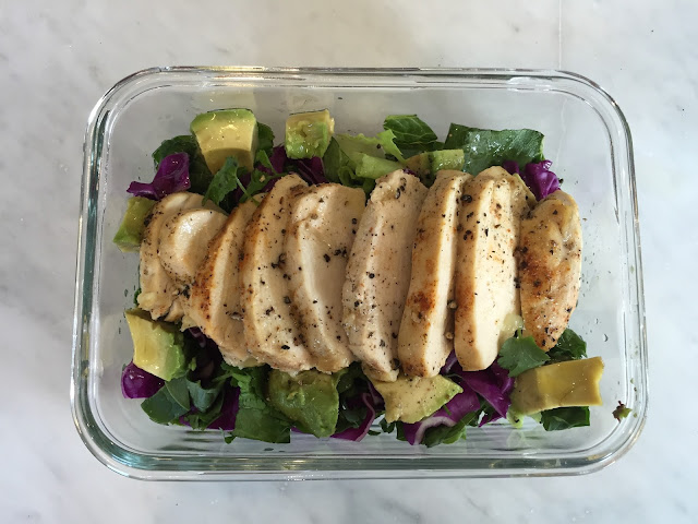 Cilantro Lemon Pepper Chicken Salad in a glass bowl on white marble