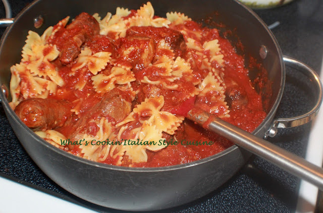 this is a big pan of bow tie pasta with meat in it