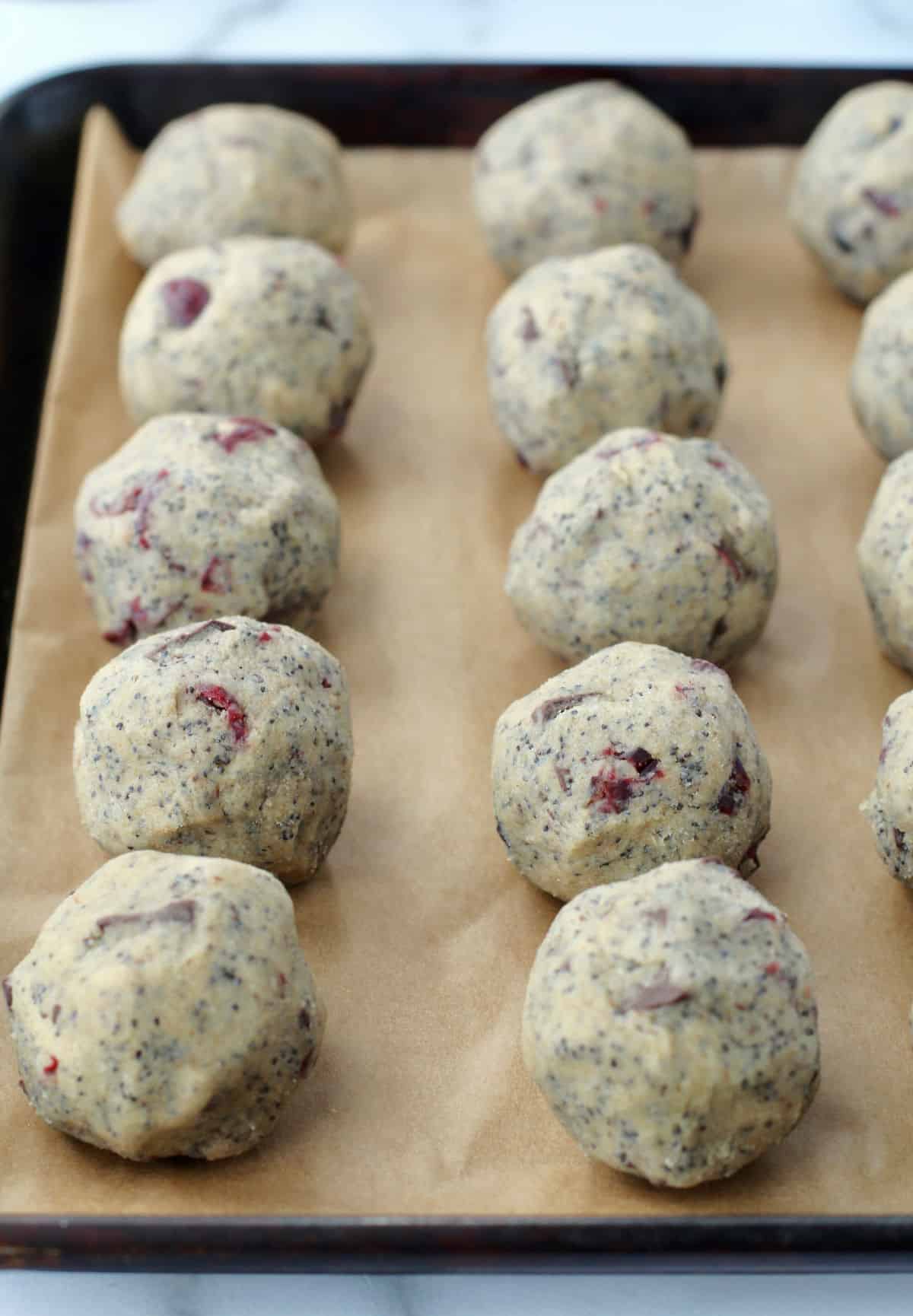 Cookie dough balls on a small baking sheet.