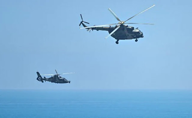 Image Attribute: Chinese military helicopters fly by Pingtan island, one of the closest points of mainland China to Taiwan.