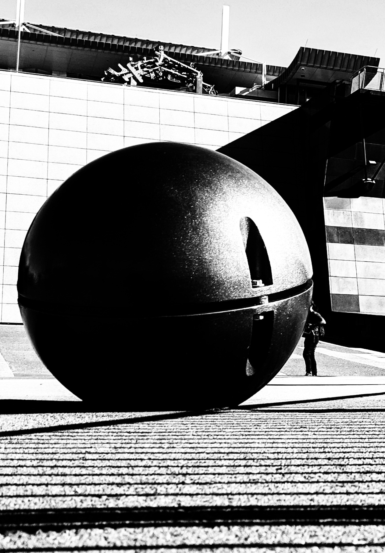 Stark black and white photo of a ball outside of a museum