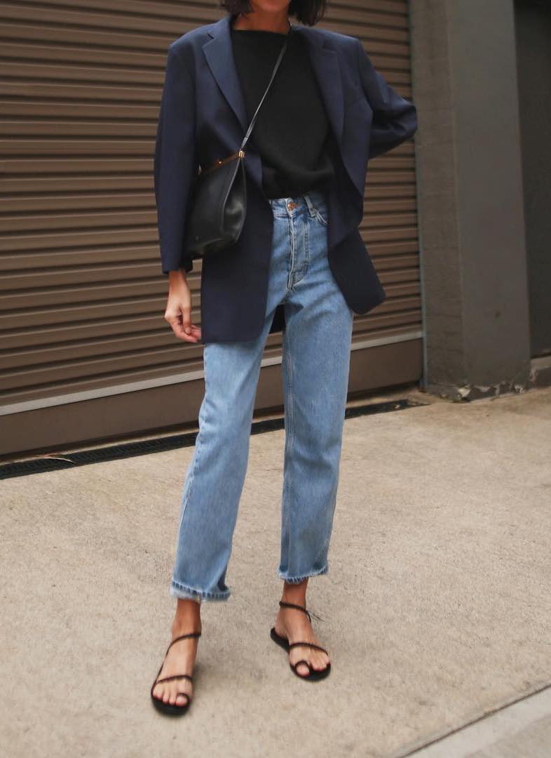 Petra Mack @pepamack viral Instagram spring outfit inspiration — navy blue blazer, black t-shirt, high-waisted jeans, and black strappy flat sandals