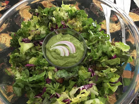 large bowl of salad with green dressing