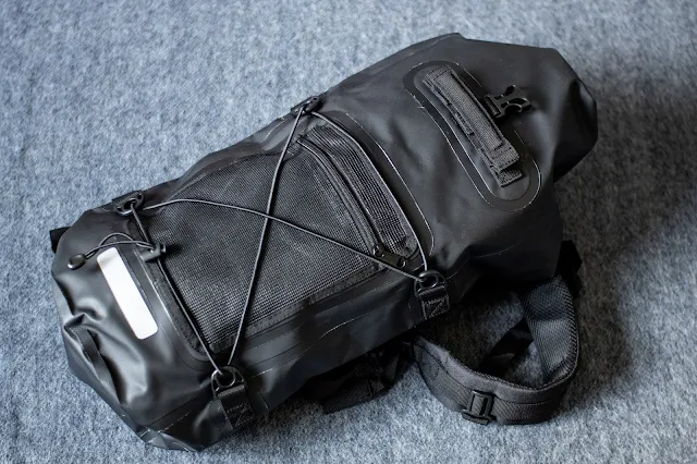 The front of a waterproof backpack in black with a reflective strip