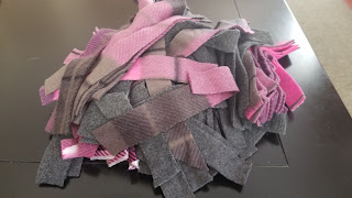 A pile of gray and pink fleece strips.