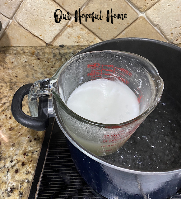 melted white paraffin wax in Pyrex measuring cup double boiler