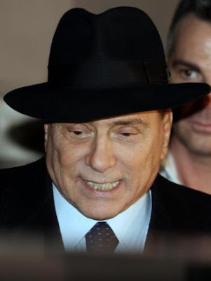 Silvio Berlusconi wearing a quite serious Borsalino hat