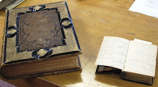 On the left, The Holy Bible, containing Old and New Testaments. together with the Apocrypha (undated, owners unknown). On the right, Tresor des ames pieuses ou divers moyens d'atteindre la perfection Chretienne, published in 1869, owned by Philomine Rouleau.