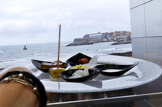 las vistas de la playa de poniente y en primer plano un plato con las distintas degustaciones