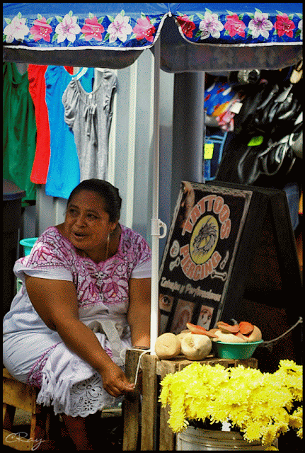 Yucatecan woman in traditional dress selling flowers in Merida Mexico