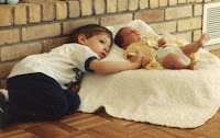 photo of toddler boy and newborn baby sister napping